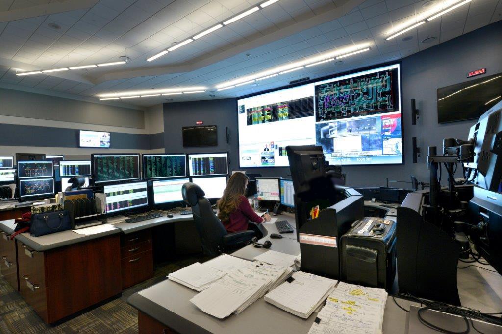 Electric utility control room with console workstations and large video display wall